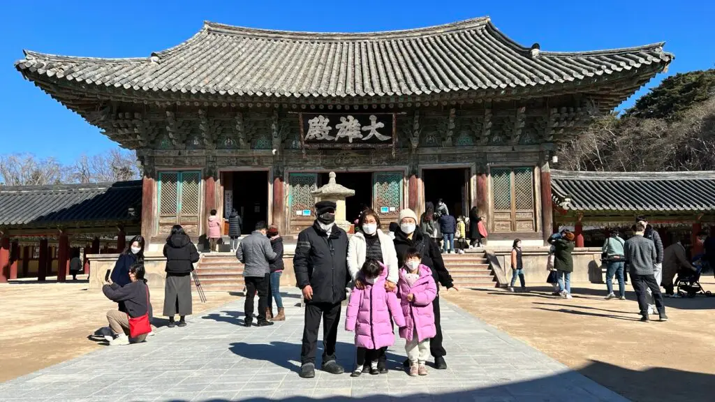 A family taking a photo in front of Daeungjeon Hall at Bulguksa Temple, Gyeongju, South Korea