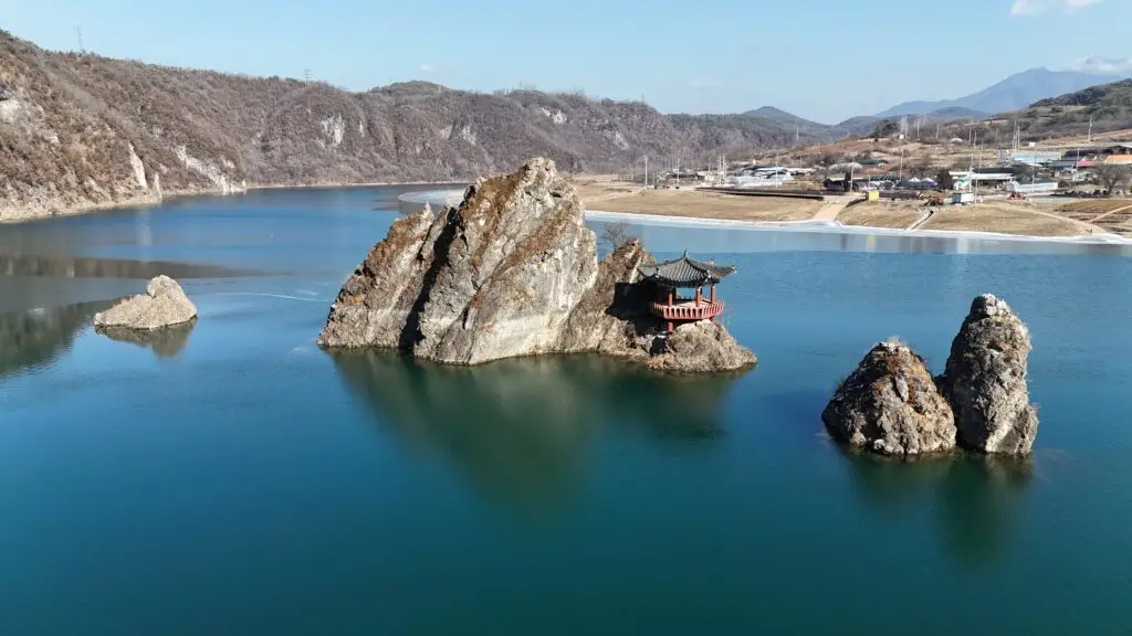 Panoramic view of 도담삼봉 in Danyang, South Korea, with three iconic rock peaks rising from the river surrounded by lush mountains.